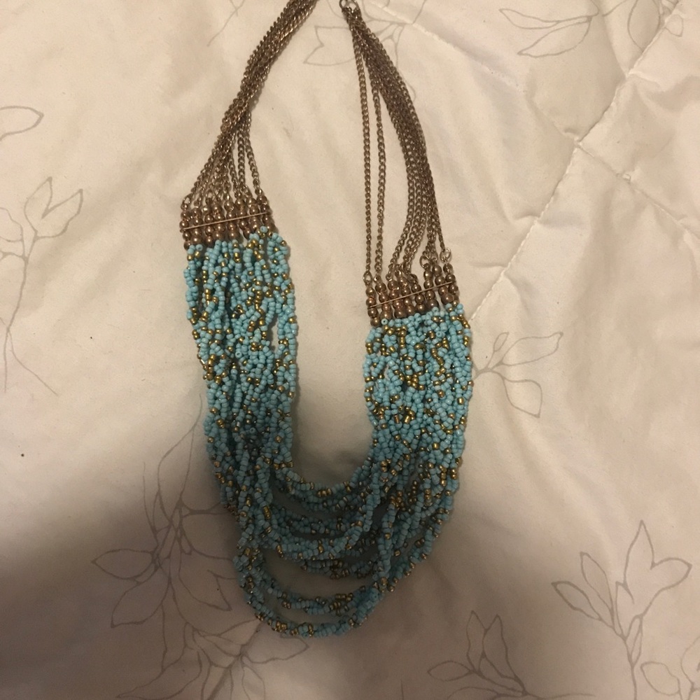 A turquoise and gold necklace.